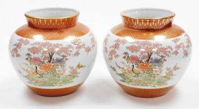 A pair of Japanese Kutani porcelain jardinieres, decorated with pheasants chrysanthemums and cherry blossom between lappet and diaper borders in gilt, seal marks to the base. 20thC, 23cm high. (2) - 3