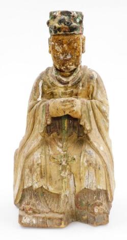 A Chinese painted wood figure, of a seated sage in flowing robes with polychrome hat, probably 18thC, 43cm high.