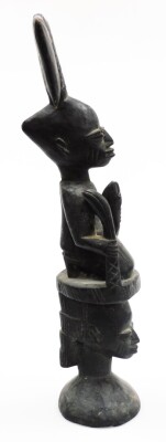 A heavily carved ebonised African tribal totem style figure, formed as two figures with elaborate features on a circular base, 54cm high. - 4