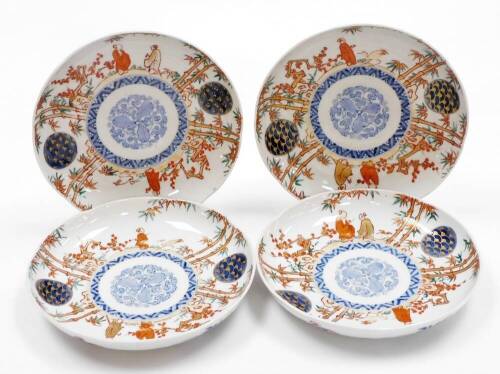 A set of four Japanese Imari porcelain plates, decorated with figures among bamboo and prunus, central underglaze blue floral medallion, four character Fuki Choshun mark (meaning Wealth, Nobility, Longevity and Youth), Meiji period. 23cm wide.