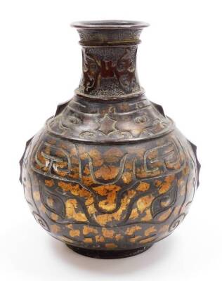 A 20thC metal vase, with compressed cylindrical stem, studded and raised with stylised animals, the globular raised and set with various geometric patterns, on a circular foot with gilt highlights, 23cm high.