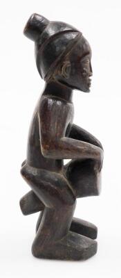 An African tribal carved figure, formed holding drum, with elaborate head dress, 34cm high. - 2