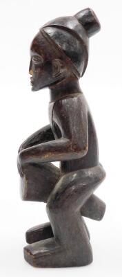 An African tribal carved figure, formed holding drum, with elaborate head dress, 34cm high. - 4