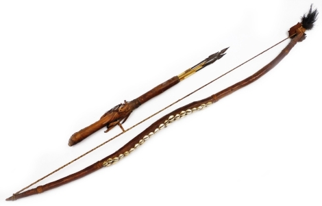 A South Sea style or tribal bow, with shaped handle set with shells and a turned leather section with robe stringing, 19cm wide, and a similar design quill with arrows.