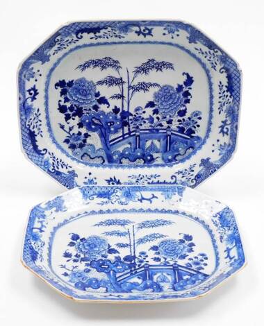 A duo of 18thC Chinese blue and white porcelain octagonal export meat plates, decorated with bamboo peony and other flowers beside a fence and flowers, shaped diaper and leaf borders, 46cm wide and 41cm wide.