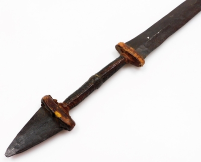 An African tribal knife, with tapering blade, turned handle with metal arrowhead pommel, 68cm wide. - 2