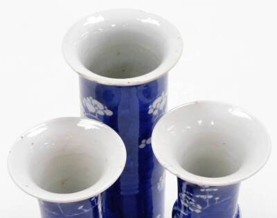 A Chinese porcelain prunus vase trio, comprising two gu shaped vases and a cylinder vase of trumpet form, decorated with prunus flowers on a blue ground, four character Kangxi marks to base of two,19thC, 19cm high. - 5