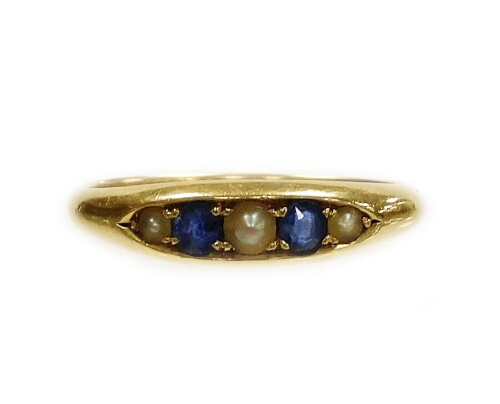 An 18ct gold sapphire and seed pearl marquise ring, set with two round brilliant cut sapphires and three seed pearls, ring size O, 3.3g all in.