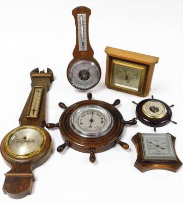 Various oak wall hanging barometers, ships wheel example, small banjo barometer with broken pediment and thermometer and barometer features, 54cm high, a shaped square example, etc. (a quantity)