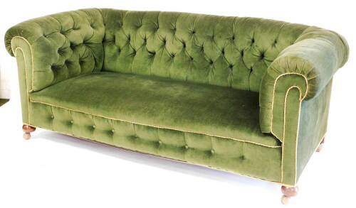 A Victorian button back Chesterfield sofa, with shaped arms, turned mahogany front bun legs terminating in castors, in later green material, 80cm high, 178cm wide, 91cm deep.