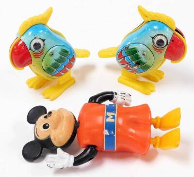 Two similar 1970's Yone Japanese plastic and tin plate parrot ornaments, one marked made in Singapore, 10cm high, and a clockwork plastic Walt Disney Mickey Mouse waving figure. (3)