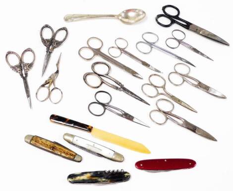 Various pen knives, scissors, etc., a part silver handled manicure set with cherub handles, Edwardian silver, Birmingham 1907, to include one pair of scissors 10cm wide, etc., pen knives, other plated scissors, etc. (a quantity)