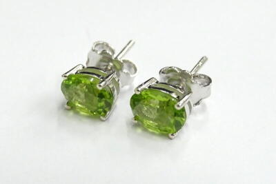 A pair of peridot studs, in silver with butterfly backs, 2.9g all in.