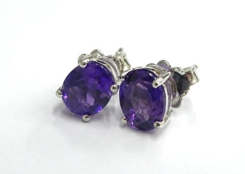 A pair of amethyst stud earrings, each with butterfly backs, in silver, 2.7g all in.