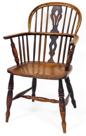 A 19thC Lincolnshire ash and elm low back Windsor chair, with shaped back, plain spindles, C shaped arms, turned supports, shaped seat, and single ring turned front legs, joined by an H stretcher, 89cm high.