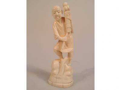 An early 20thC Japanese carved ivory Okimono figure of a young male worker with a scythe