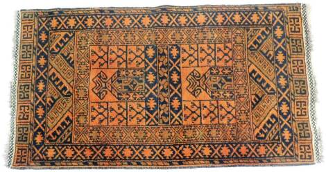 A Persian type rug, in orange and black ground, with a sword and motif border, bearing fabric label to rear, no. 00345, with tassel ends, 153cm x 82cm.