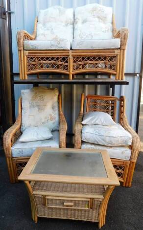 A bamboo style cane four piece conservatory suite, comprising two seater settee, 125cm wide, two armchairs, and a glass topped coffee table with drawer beneath.