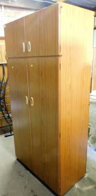 A Schreiber teak double wardrobe, the top section with two cupboard doors, above two larger cupboard doors with single hanging rail, 190cm high, 89cm wide, 53cm deep.