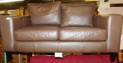 A brown leather two seater sofa.