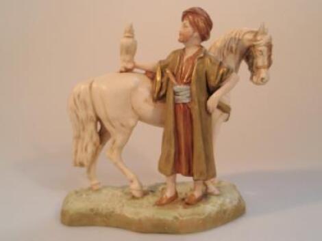 A Royal Dux porcelain group of an Arab falconer standing with his horse (AF)