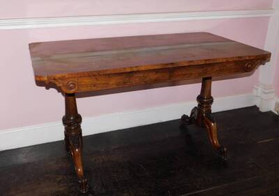 An early Victorian rosewood library table by Holland & Sons, the rectangular top above two frieze drawers, on turned end supports, carved with paterae, leaves, etc., with splayed scroll carved feet, the right hand drawer is marked 'From Holland & Sons' an