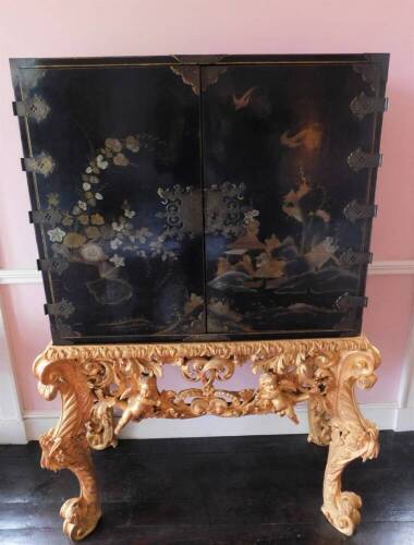 A late 17th/early 18thC Japanned cabinet, decorated in gilt and silver with flowers, buildings, etc. on a black ground, enclosing a fitted interior with an arrangement of twelve small drawers with similar decoration, embellished with birds, figures, bridg