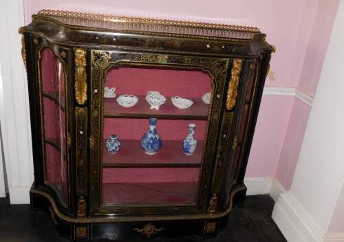 A Victorian Boulle and ebonised credenza, with a pierced gilt gallery, a concave frieze decorated with putti picked out in ivory, etc., enclosing a velvet lined interior, flanked by two further serpentine shaped doors, on a plinth base, 127cm high, 142cm