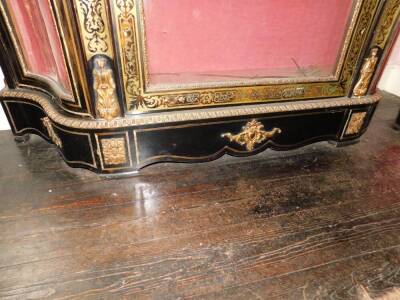 A Victorian Boulle and ebonised credenza, with a pierced gilt gallery, a concave frieze decorated with putti picked out in ivory, etc., enclosing a velvet lined interior, flanked by two further serpentine shaped doors, on a plinth base, 127cm high, 142cm - 8