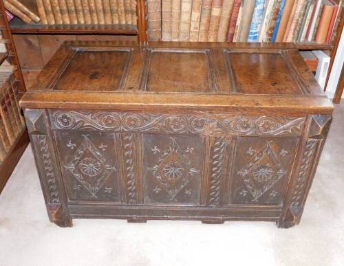 A late 17thC oak coffer, with a triple plank hinged top, the front carved with lozenges, scrolls and patera, on stiles, 60cm high, 103cm wide, 57cm deep.