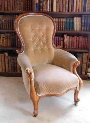 A Victorian mahogany show frame armchair, upholstered in button beige fabric, on cabriole legs with ceramic castors.