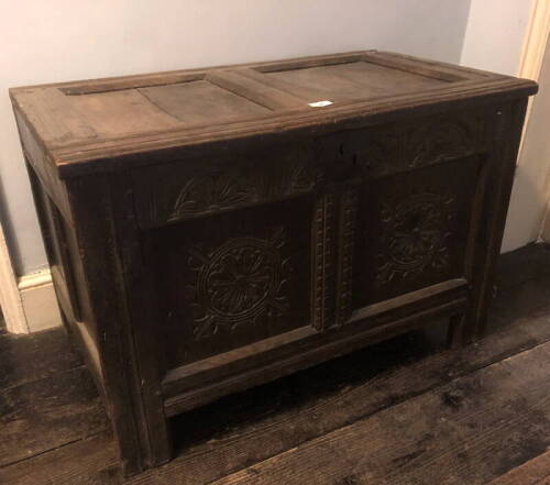 A 17thC two panel coffer, with wainscot top having slight reducing, demi-lune carved frieze over a rondel front, raised on stiles, 58cm high, 85cm wide, 50cm deep.