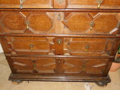 A late 17th/early 18thC oak chest of drawers, the planked top with a moulded edge, above four graduated panelled drawers each with brass pear drop handles, on bun feet, 98cm high, 101cm wide, 58cm deep. (AF) - 3