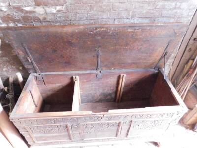 A large 17thC carved poker work walnut coffer, the lid with iron strap hinges and carved figural and lion decoration in blind fret designs, repeated to the front and with paneling and with iron bracket bound corners, on a later plinth base with shallow br - 3