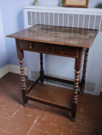 A late 17th/early 18thC oak side table, the rectangular plank top with a moulded edge, frieze drawer with brass drop handles, on bobbin turned supports, 74cm high, the top 65cm wide, 53cm deep.