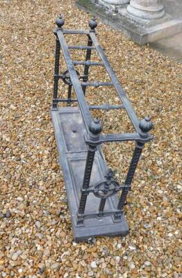 A Victorian cast iron umbrella stand, with five divisions, on spiral end supports, headed by loaded finials, the rectangular base with two dished drip trays, each with a central handle, on bracket feet, 69cm high, 98cm wide. - 2