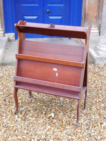 An Edwardian mahogany book and folio stand, with triangular end supports and slatted divisions on cabriole legs with brass castors, Army and Navy Makers label to underside, 93cm high, 66cm wide.