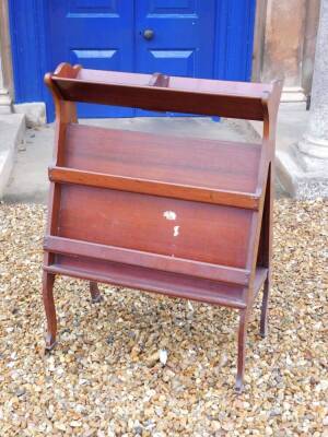 An Edwardian mahogany book and folio stand, with triangular end supports and slatted divisions on cabriole legs with brass castors, Army and Navy Makers label to underside, 93cm high, 66cm wide.