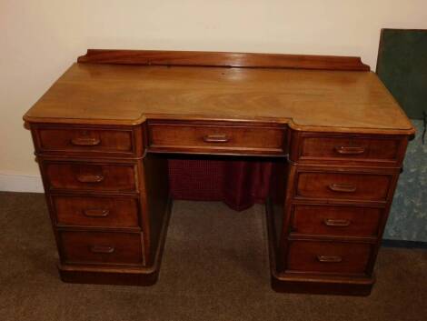 A Victorian mahogany pedestal desk, of inverted breakfront form, with a raised back, the top with a moulded edge above an arrangement of nine drawers, each with a horizontal moulded wooden handle, on plinth base, 75cm high, 130cm wide, 58cm deep.