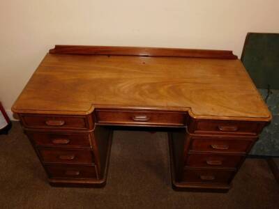 A Victorian mahogany pedestal desk, of inverted breakfront form, with a raised back, the top with a moulded edge above an arrangement of nine drawers, each with a horizontal moulded wooden handle, on plinth base, 75cm high, 130cm wide, 58cm deep. - 2