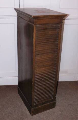 An early 20thC Lebus oak filing cabinet, the top with a moulded cornice above a tambour door enclosing eight drawers, stamped to the escutchoen Lebus Cabinet, on a plinth base, 116cm high, 37cm wide, 50cm deep.