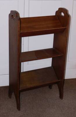 An early 20thC oak book stand, with pierced side handles and shaped end supports 91cm high, 50cm wide.