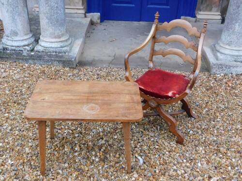 A late 19thC continental walnut Savonarola type chair, the ladderback with champered supports and turned finials, shaped arms and a velvet padded seat on X shaped supports and stretcher, and a walnut veneered side table on square tapering beech legs. (2)