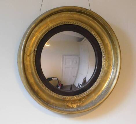 An early 19thC gilt Chester convex wall mirror, with an ebonised slip, later plate, the frame with moulded and beaded decoration, 51cm diameter.