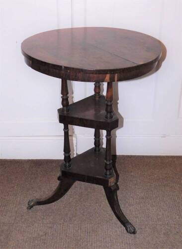 A early Victorian rosewood washstand, the circular top above two triangle undertiers, each with turned supports and splayed legs with brass castors, 73cm high, 51cm diameter. (AF)