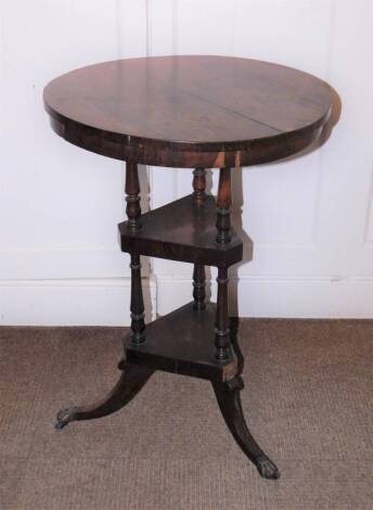 A early Victorian rosewood washstand, the circular top above two triangle undertiers, each with turned supports and splayed legs with brass castors, 73cm high, 51cm diameter. (AF)