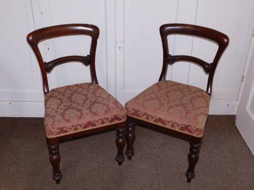 A pair of Victorian mahogany balloon back dining chairs, each with a padded seat on turned tapering legs.(AF)