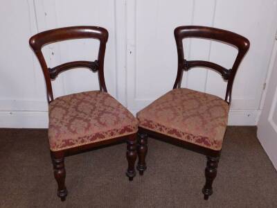 A pair of Victorian mahogany balloon back dining chairs, each with a padded seat on turned tapering legs.(AF)