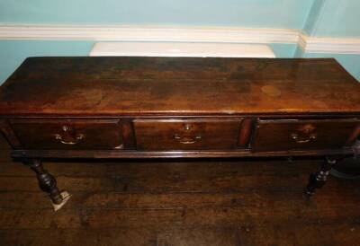 An early 18thC oak dresser base, the top with a moulded edge above three frieze drawers each with drop brass handles, on turned front legs 83cm high, 176cm wide, 47cm deep. (AF) - 2