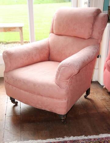 A Victorian mahogany armchair, upholstered in coral damask fabric, on turned legs with ceramic castors.